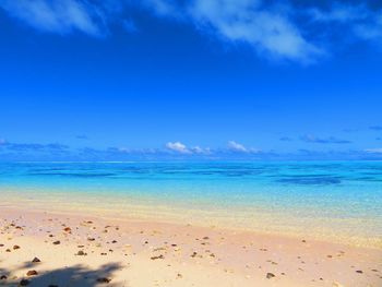 Scenic view of beach against blue sky