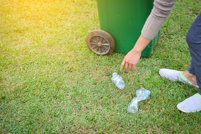 Low section of young woman cleaning park