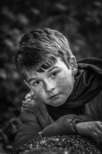 Close-up portrait of boy with freckles on face outdoors