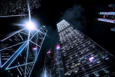 Low angle view of illuminated buildings against sky at night