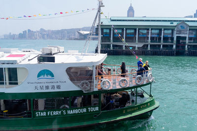 People on boats in sea against buildings