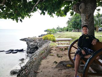 People sitting on shore by sea