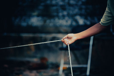Midsection of man holding rope
