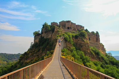 Footbridge amidst mountains against sky