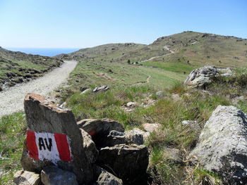 Trail marker on mountain against clear sky