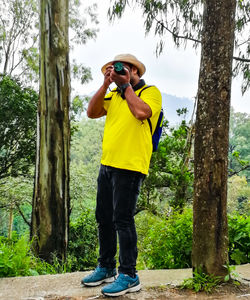 Full length of man photographing while standing on street