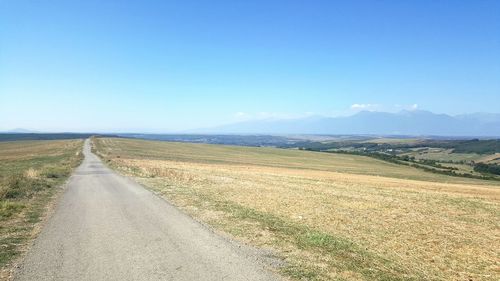 Empty road passing through field