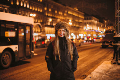 Portrait of young woman in city during winter