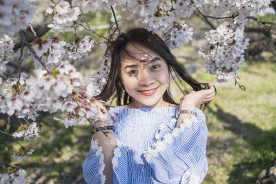 Portrait of a beautiful young woman with cherry blossom