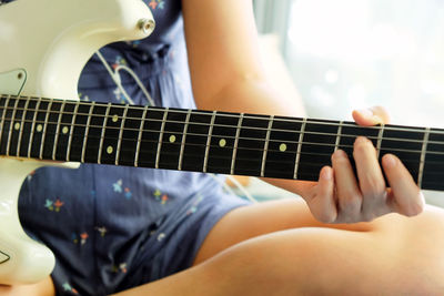 Midsection of man playing guitar