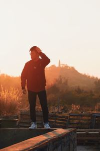 Full length of man standing against sky during sunset