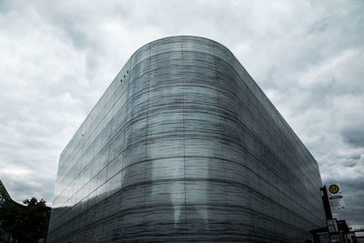 Low angle view of modern building against cloudy sky