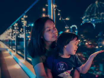 Smiling mother and daughter at night