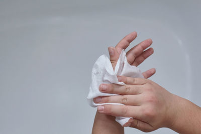 Woman wiping hands with napkin over white background