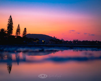 Scenic view of lake against romantic sky at sunset