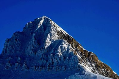Scenic view of snowcapped mountains against clear blue sky