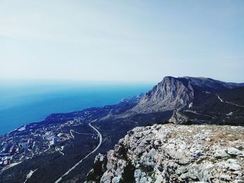 Scenic view of sea and mountains against sky