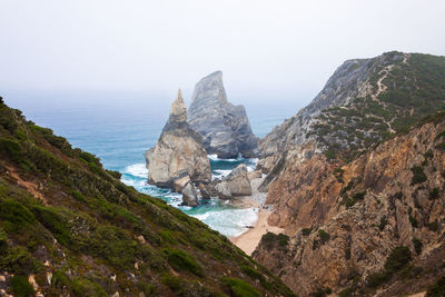 Scenic view of sea and mountains against sky