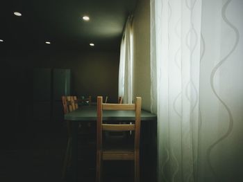 Empty chairs and table in illuminated room