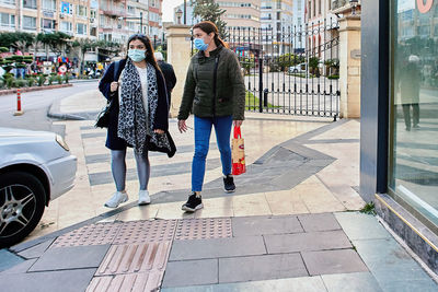 People walking on footpath in city