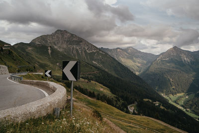 Scenic view of road by mountains against sky