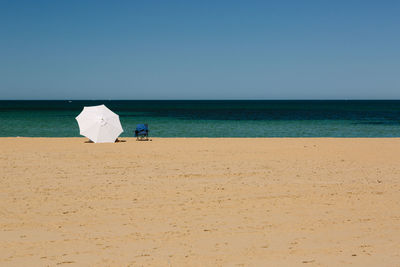 Beach umbrella on beach against sky