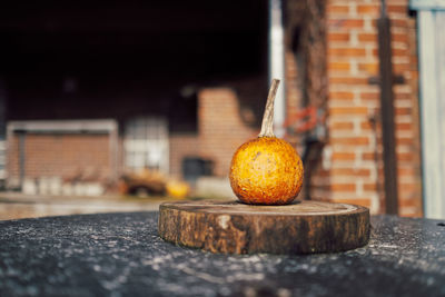 Close-up of orange on table against wall