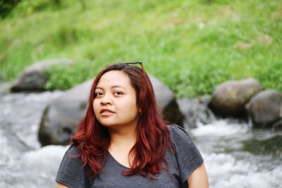 Portrait of beautiful young woman standing on rock