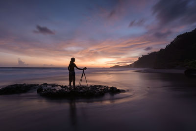 Silhouette man standing on beach against sky during sunset, surumanis beach