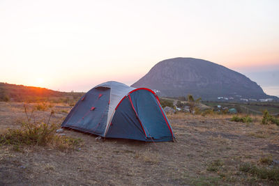 Installed tourist tent in the mountains with a view of the sea and sunrise. domestic tourism, active