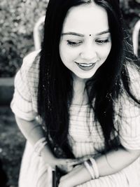 High angle view of smiling young woman looking away while sitting outdoors