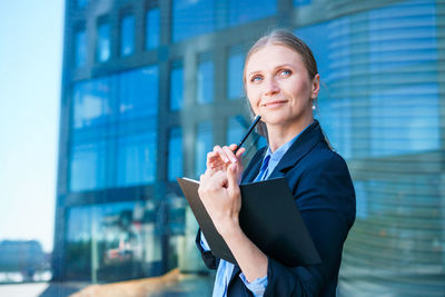 Successful businesswoman taking notes while walking outdoors. business woman