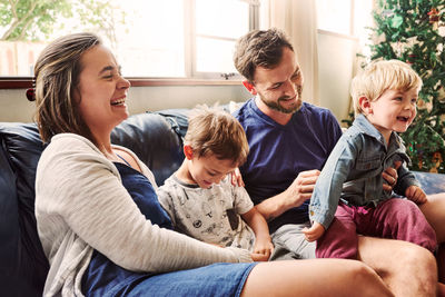 Cheerful family sitting on sofa at home