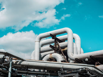 Low angle view of gas pipes at industry against sky