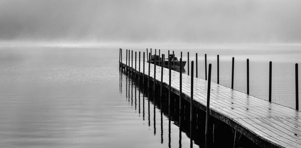 Pier on lake against sky