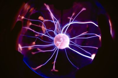 Close-up of illuminated lighting equipment against black background