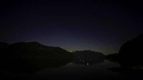 Scenic view of lake against sky at night