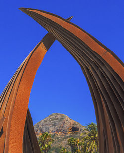 Low angle view of mountain against clear blue sky