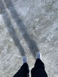 Low section of person standing by water