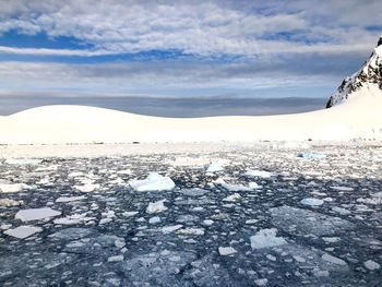 Scenic view of frozen lake against cloudy sky