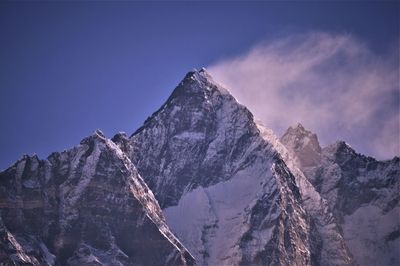 Low angle view of snowcapped mountains against sky