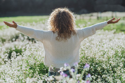 Cropped hand of woman with arms raised on field