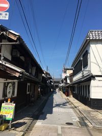 Street amidst buildings against blue sky