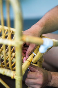 Cropped hands of man making wooden chair in workshop