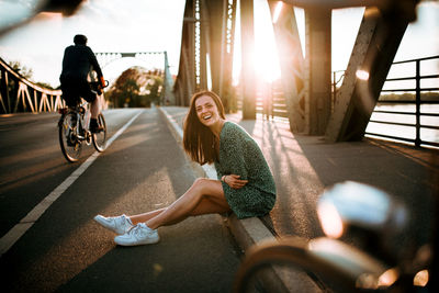 Woman riding bicycle on road in city