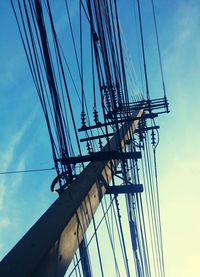 Low angle view of electricity pylon against blue sky