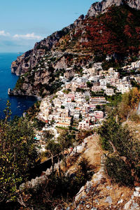 Aerial view of town by sea against sky