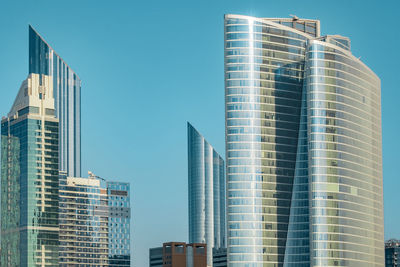 Low angle view of modern buildings against clear blue sky