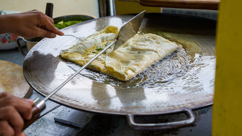 Close-up of person preparing food, traditional javanese street food called martabak telor. 