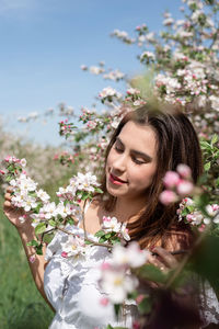 Portrait of smiling young woman standing amidst plants